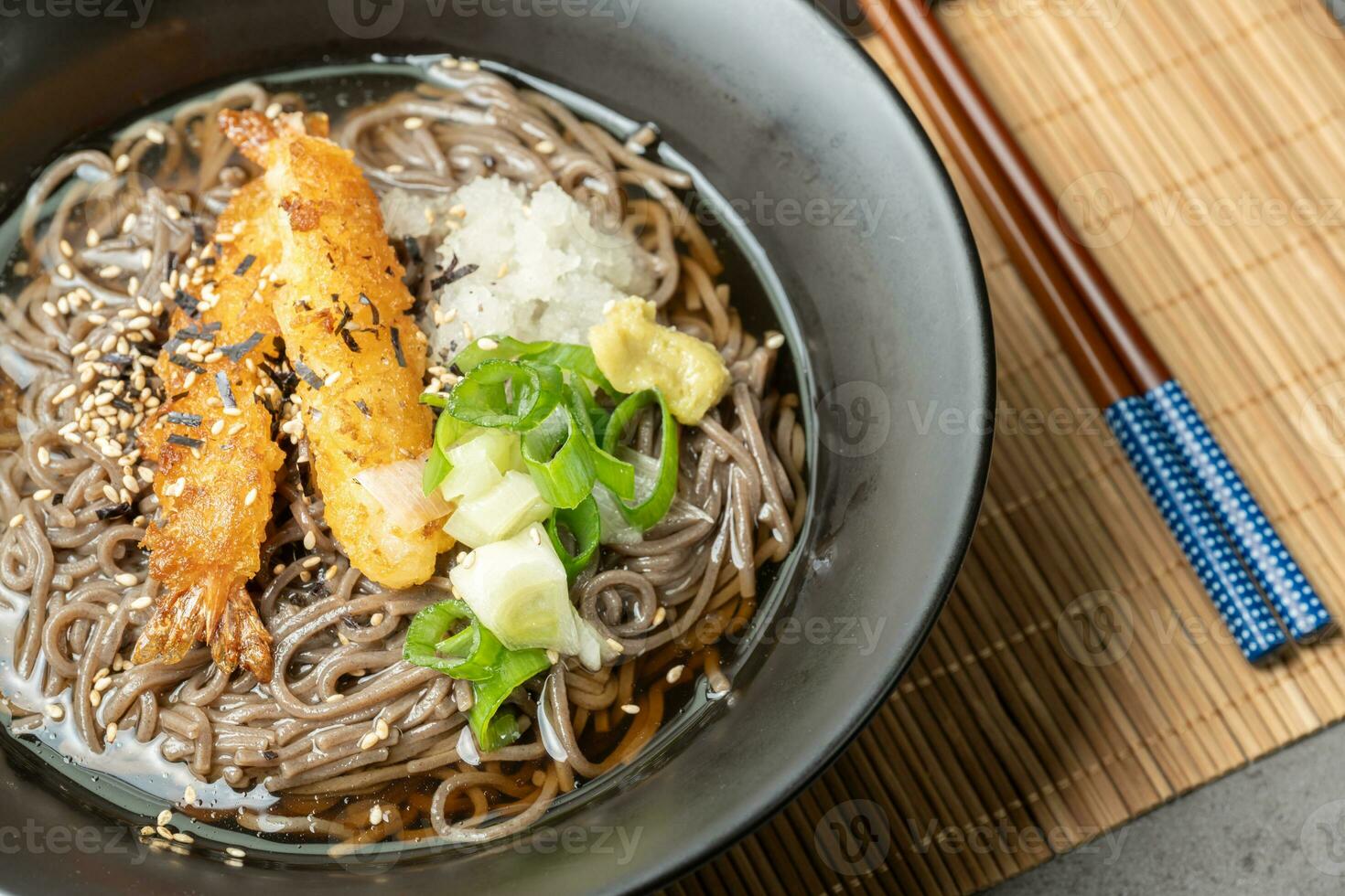 A summer dish of cold wheat noodles with fried shrimp in a black bowl photo