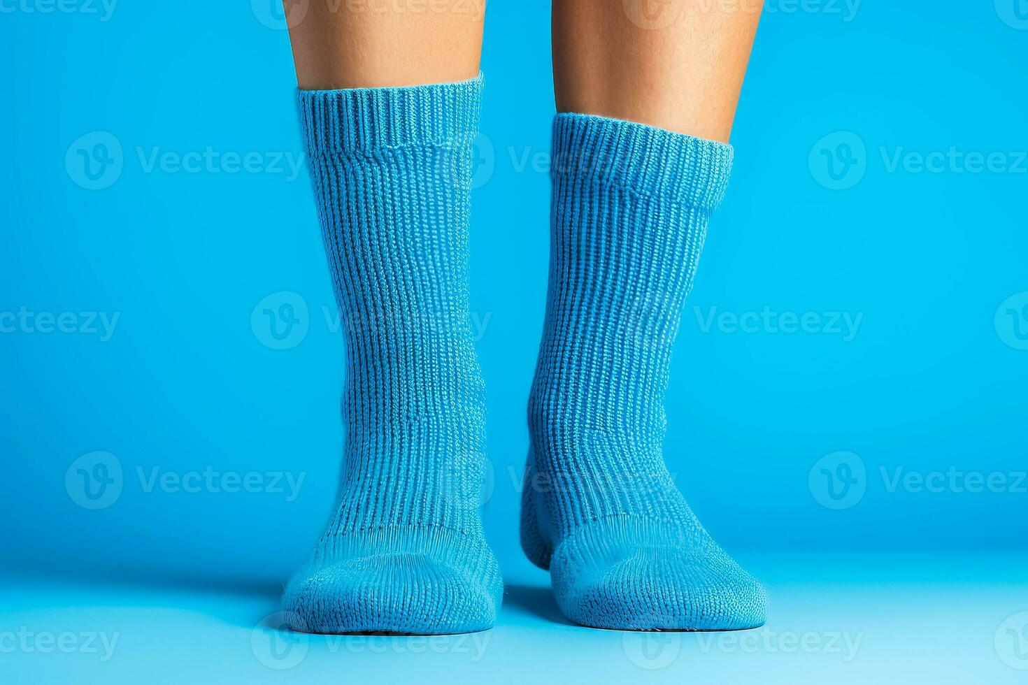 Legs in knitted woolen blue socks isolated on solid background photo