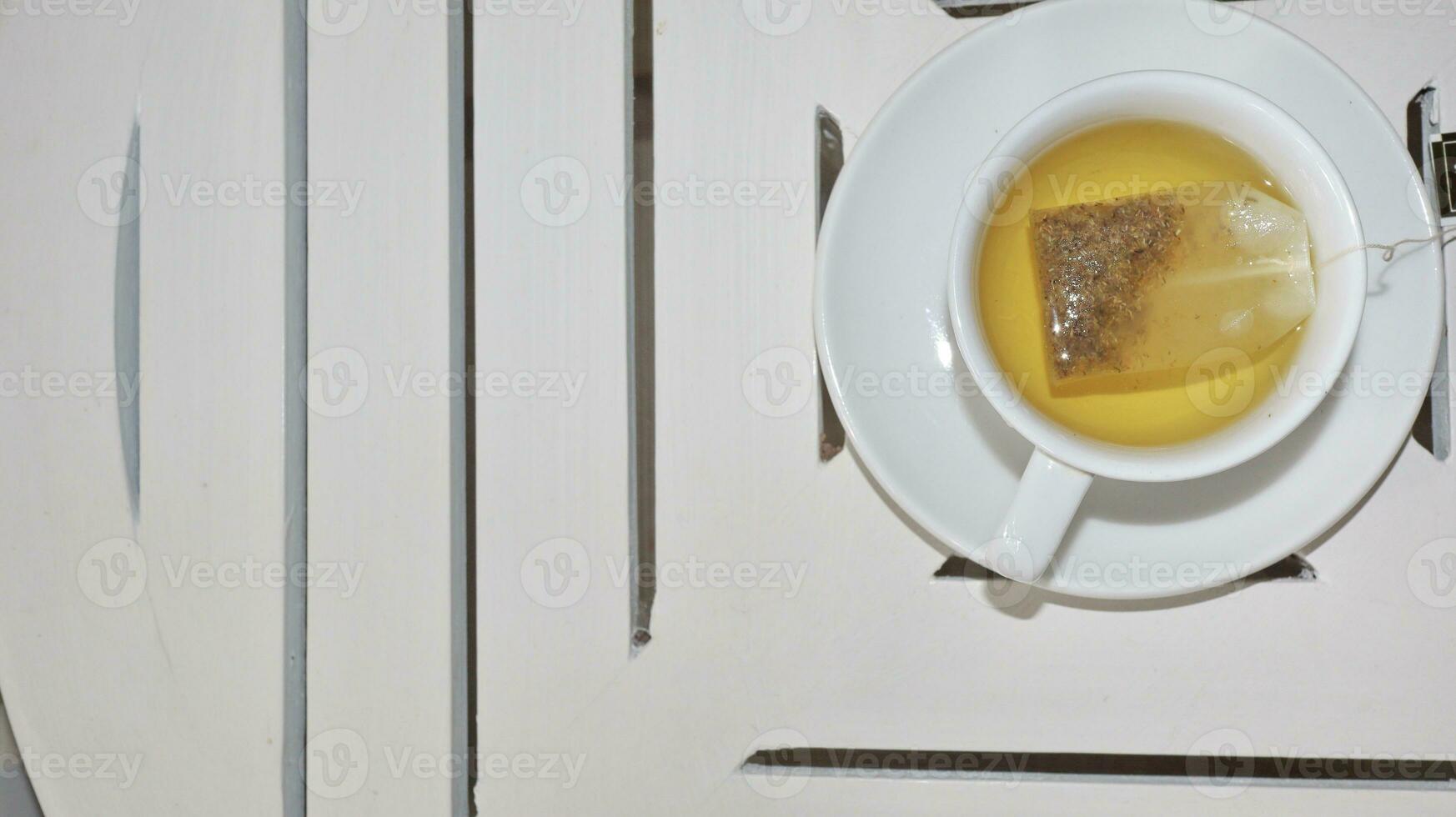 Healthy chamomile tea is poured into a white cup photo