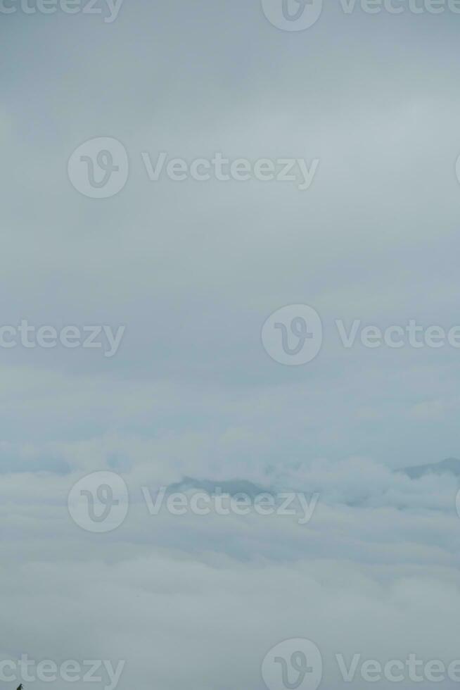 Mountain range with visible silhouettes through the morning blue fog. photo