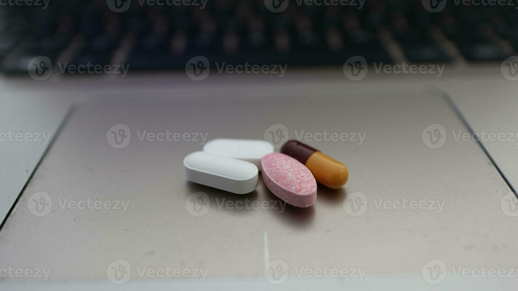 Various types of drugs, placed on a laptop keyboard photo