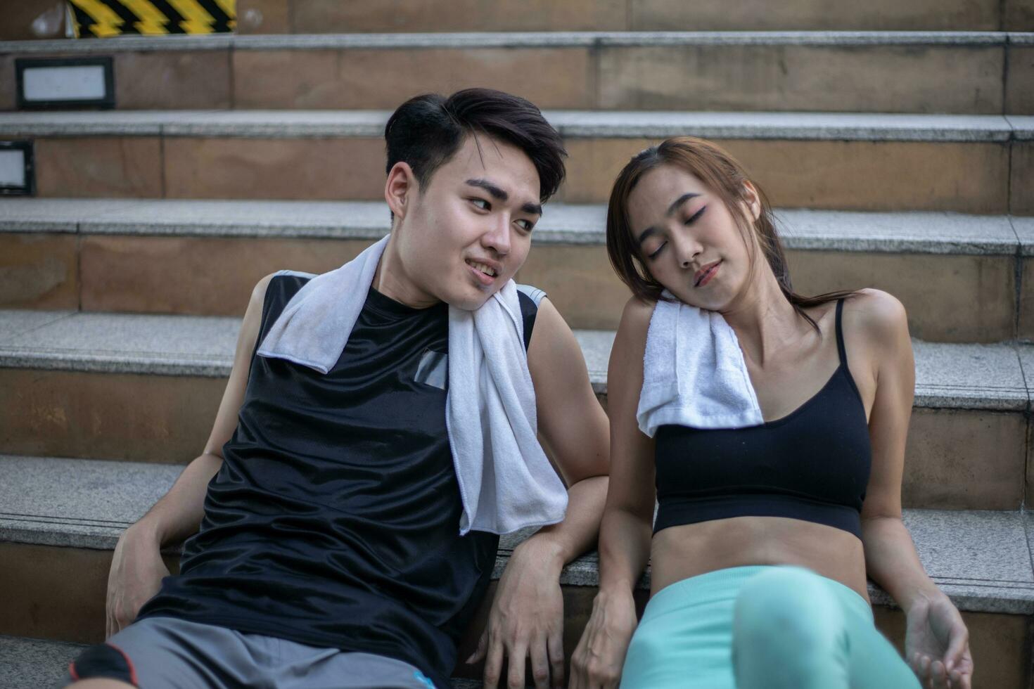 Tired couple after fitness and exercise time for performance on the stairs. photo