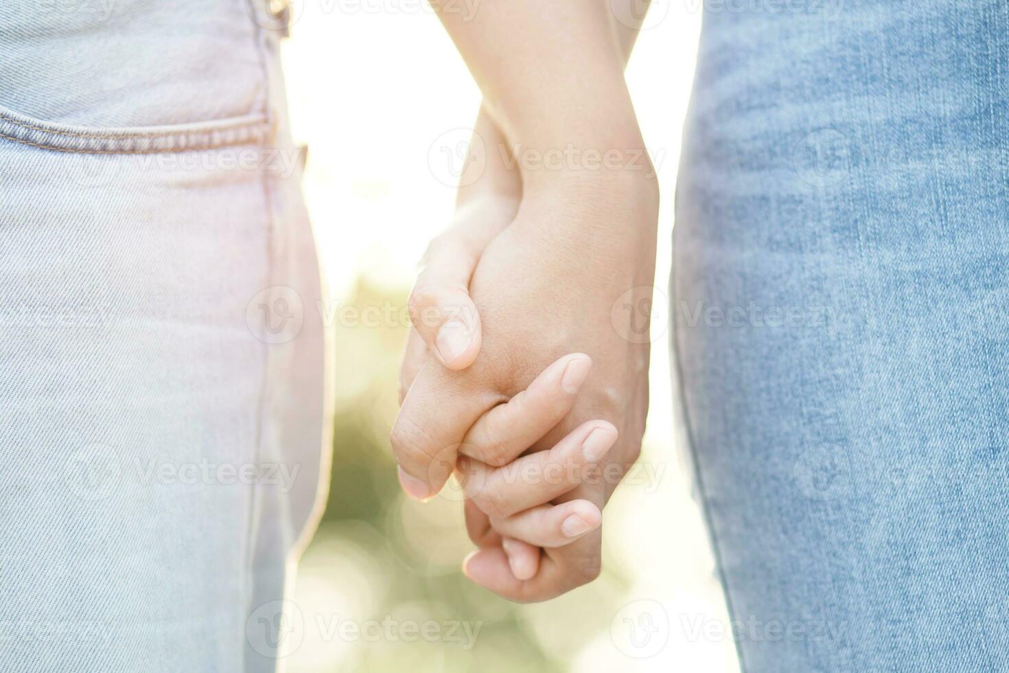 Couple lovers romantic holding hands towards with bright sun flare in public parks, or close up view in a conceptual image first love adolescent young relationship. lover photo