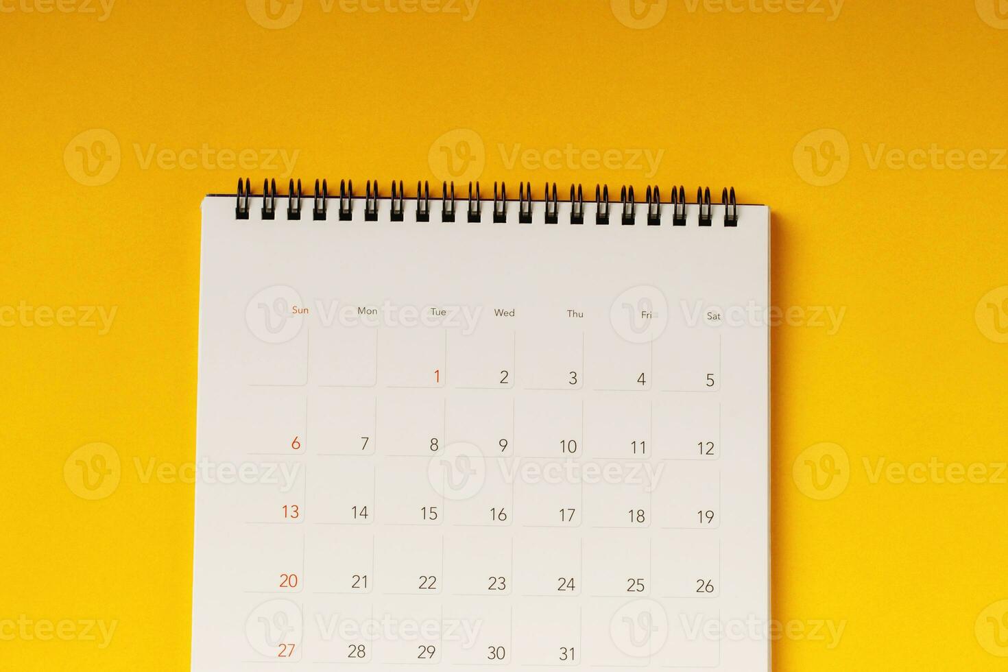 calendar month schedule to make appointment meeting or manage timetable each day lay and pen on yellow background for planning work and travel concept. photo