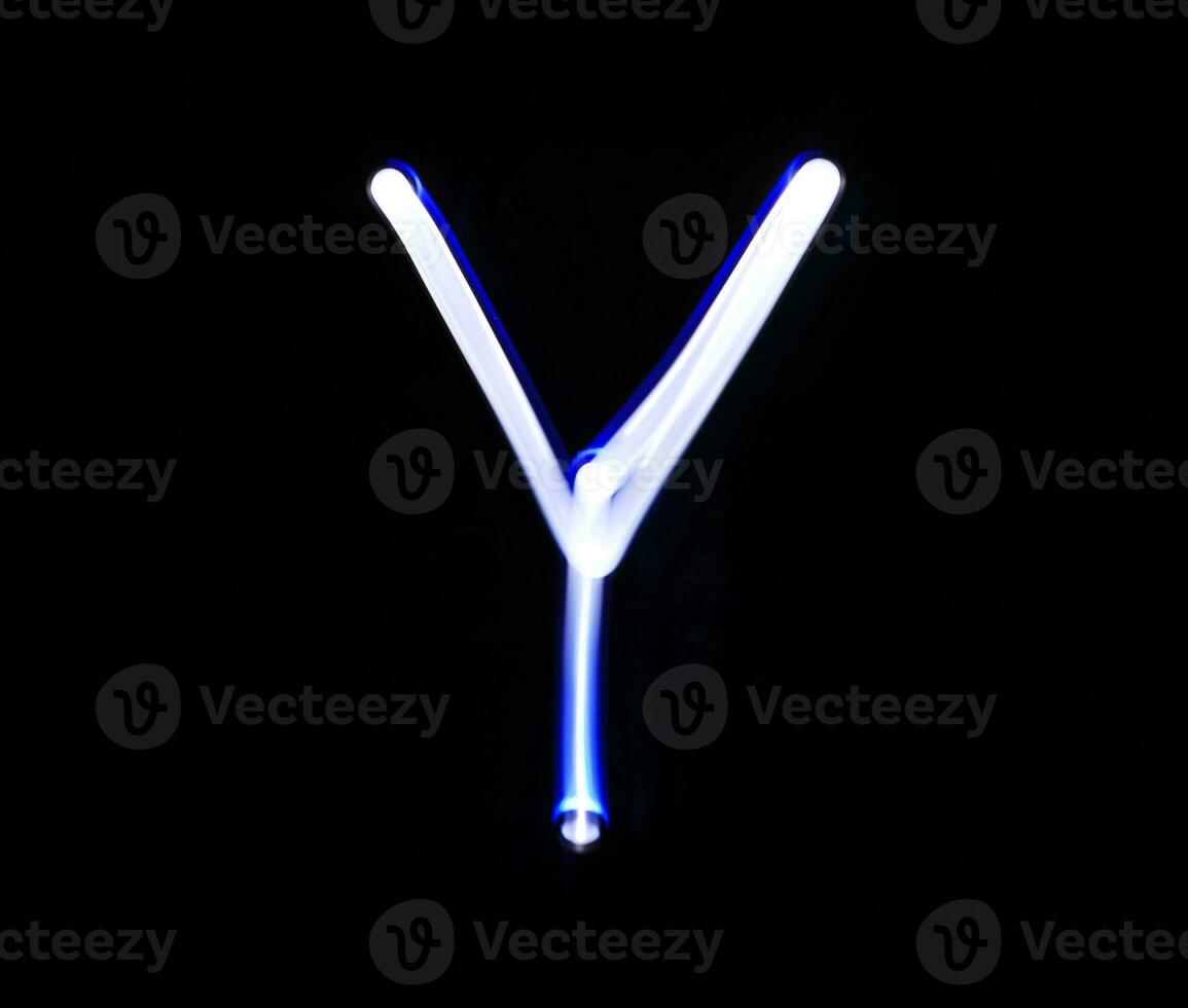 Y Yankee alphabet hand writing blue light  over black background. photo