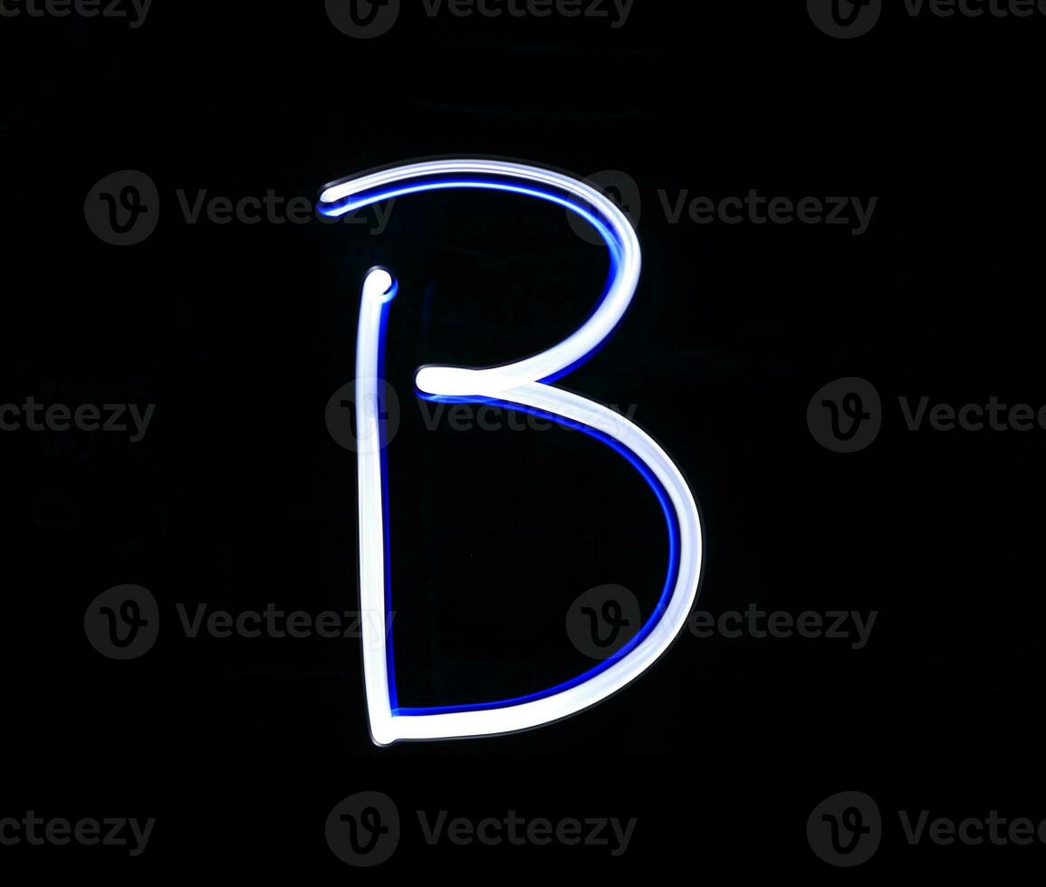 B Baker alphabet hand writing blue light  over black background. photo