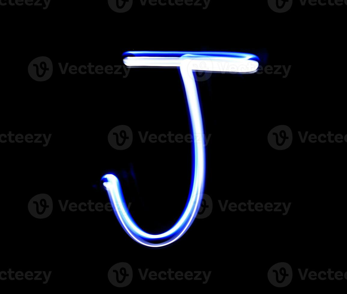 J Jimmy alphabet hand writing blue light  over black background. photo