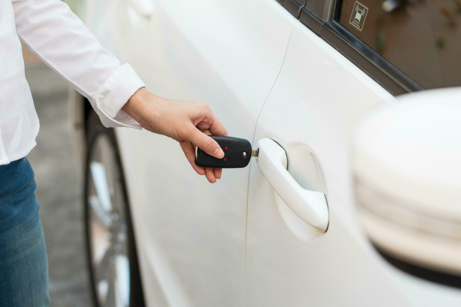 Female hand open the white car on key system automatic. photo