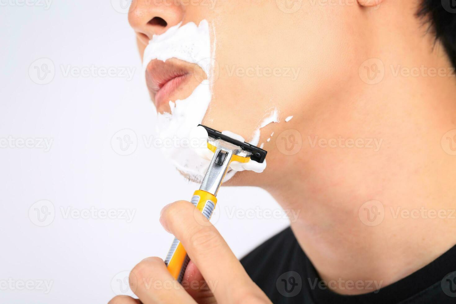 Close up young man shaving his face. photo