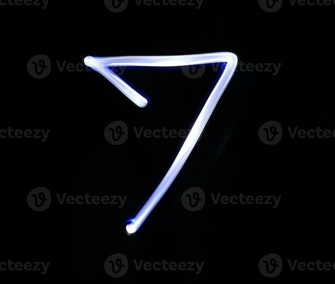 Seven blue light digit hand writing over black background. photo