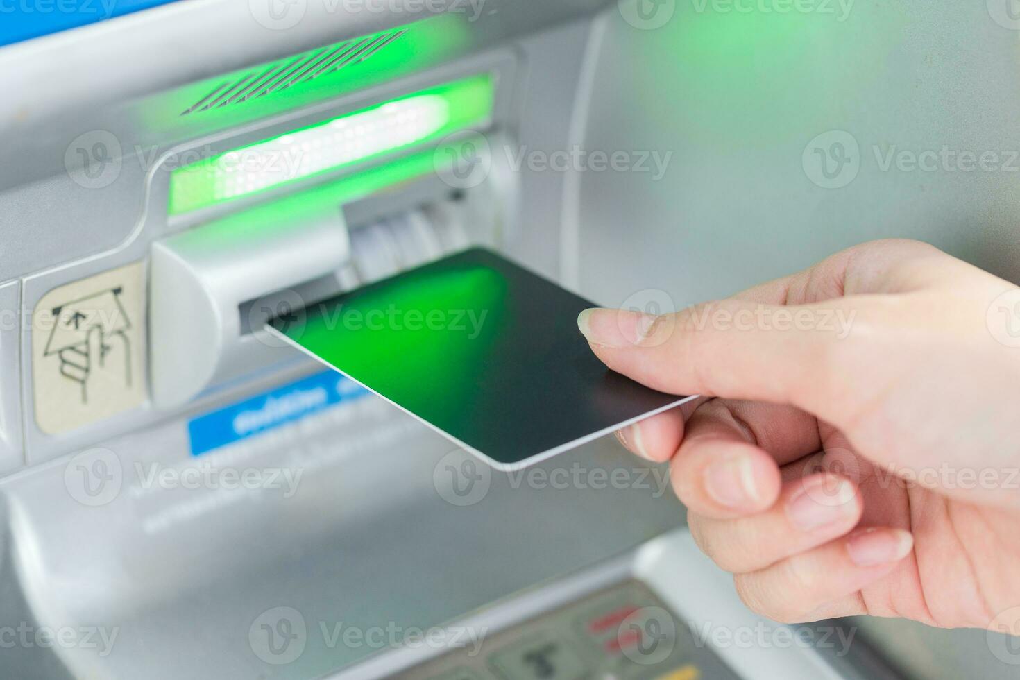 Close up hand inserting card into ATM. photo