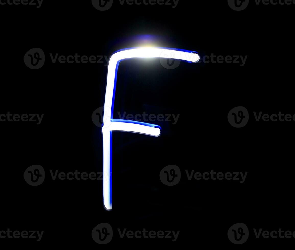 E Easy alphabet hand writing blue light  over black background. photo