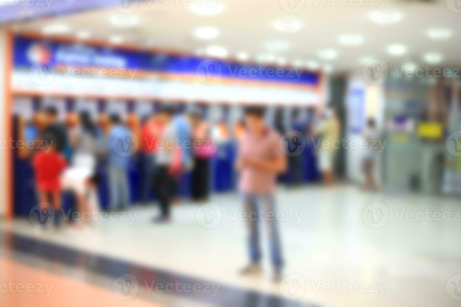 Blurry de-focused background people withdraw money automatic teller machine. photo