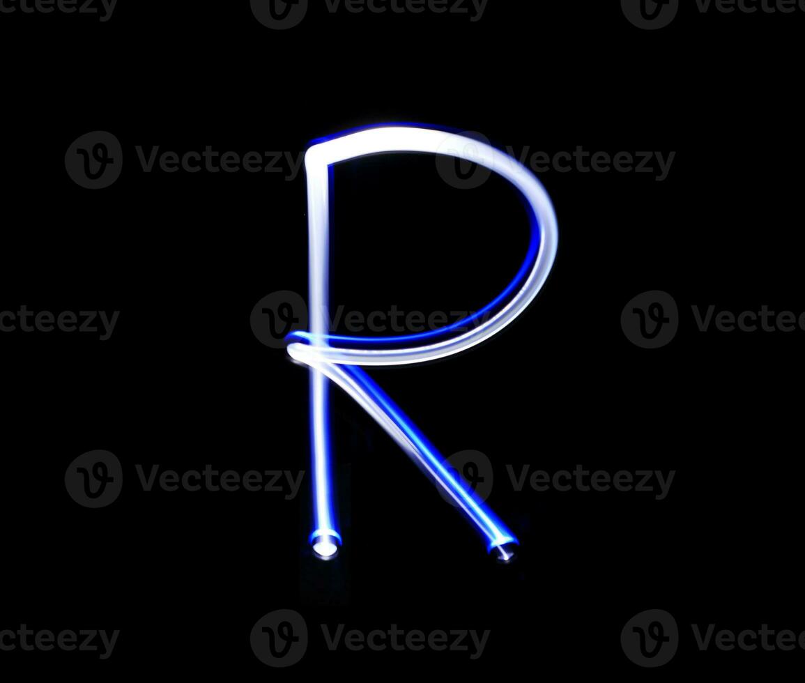 R Romeo alphabet hand writing blue light  over black background. photo