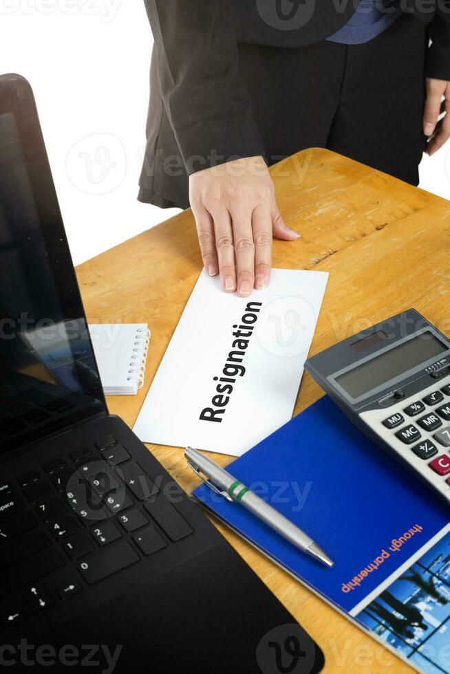 Hand holding resignation letter on the desk of the boss. photo