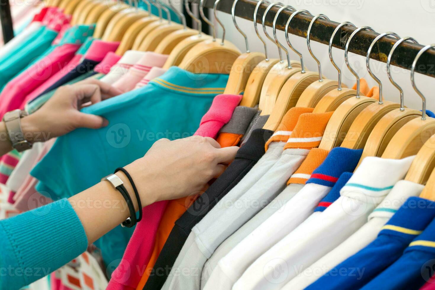 joven mujer mirando nuevo camisa compras en almacenar. foto