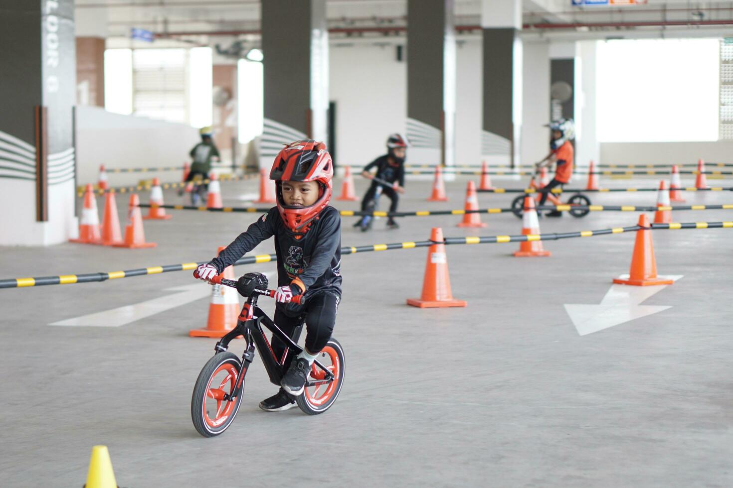 Depok-Indonesia, 29 07 2023 - Indonesian kids from 2-5 years old races on balance bike in a parking area, sportmanship training photo