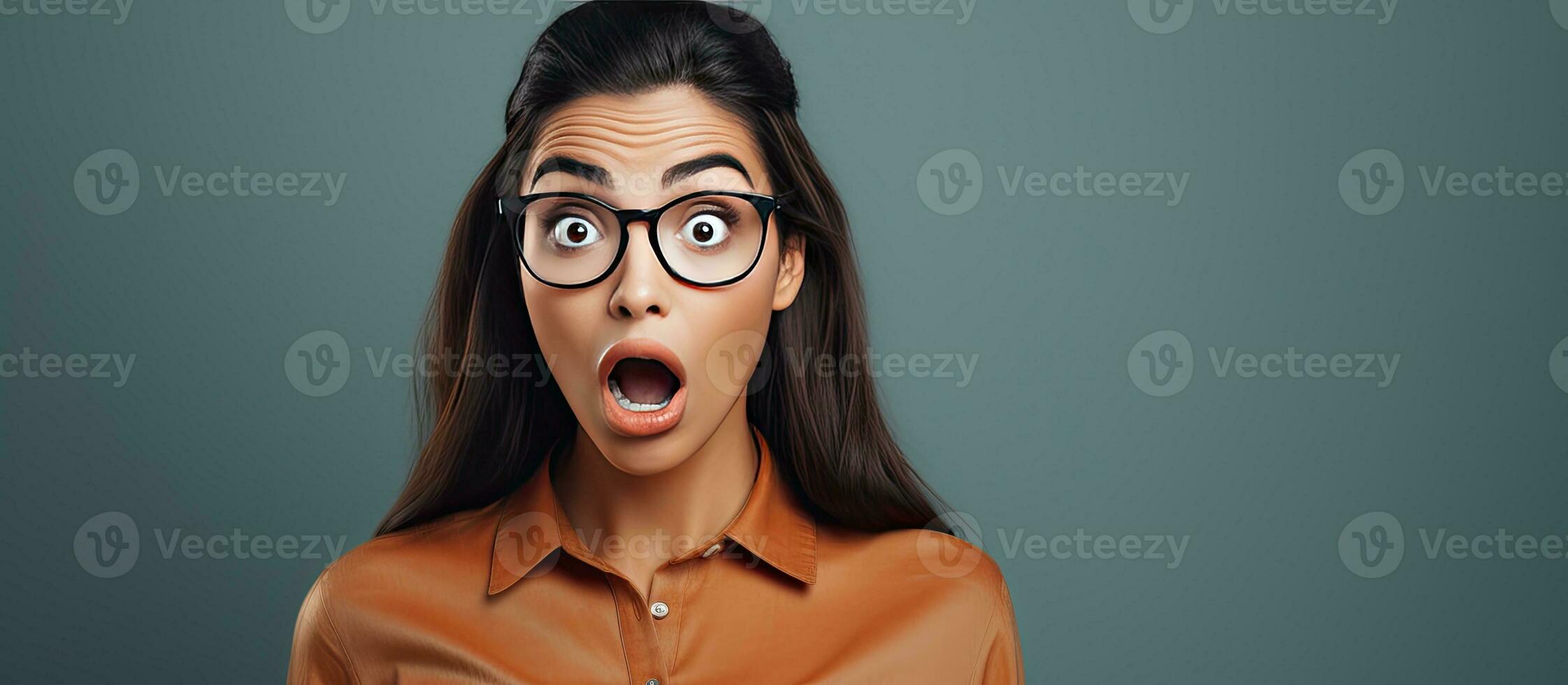Shocked and surprised young woman pointing with amazed expression photo