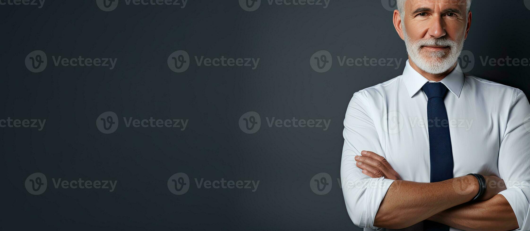 Studio half portrait of a senior man in a shirt and tie standing with arms crossed against an isolated background Side profile with copy space photo