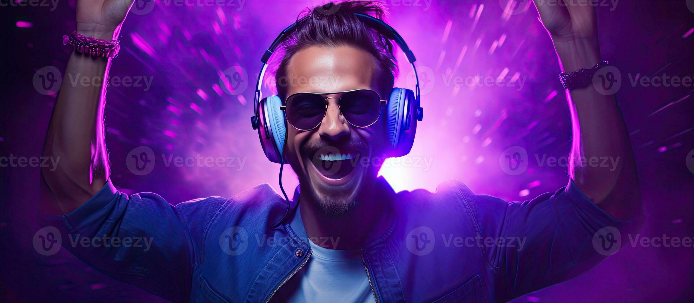 Positive man listening music with headphones, dancing on dark neon  background. Stylish student guy enjoying life, active energy, inspired  dance concept - a Royalty Free Stock Photo from Photocase