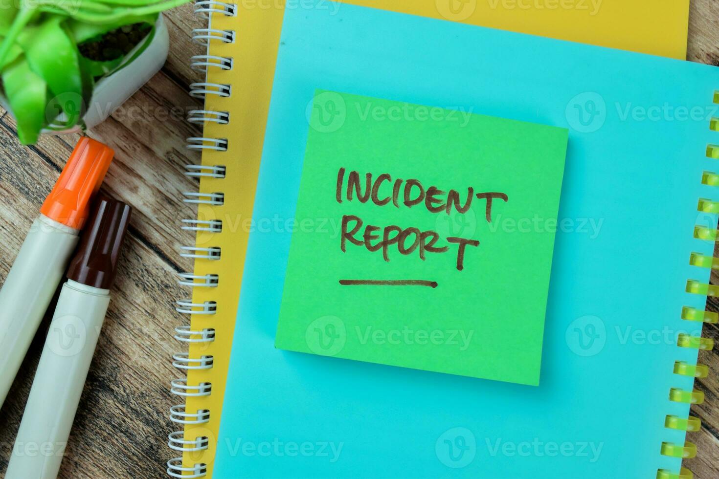 Concept of Incident Report write on sticky notes isolated on Wooden Table. photo