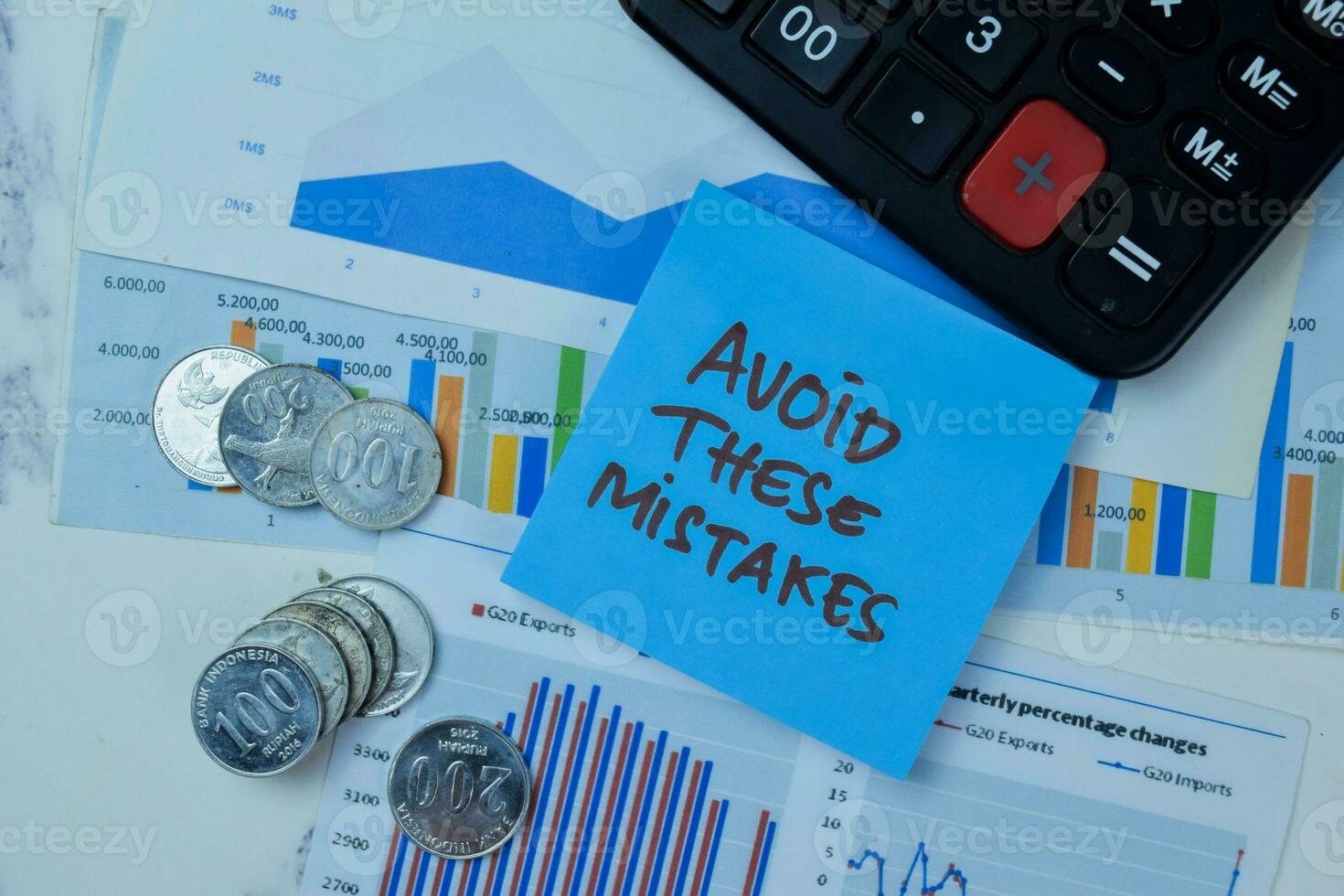 Concept of Avoid These Mistakes write on sticky notes with Indonesian Currency isolated on Wooden Table. photo