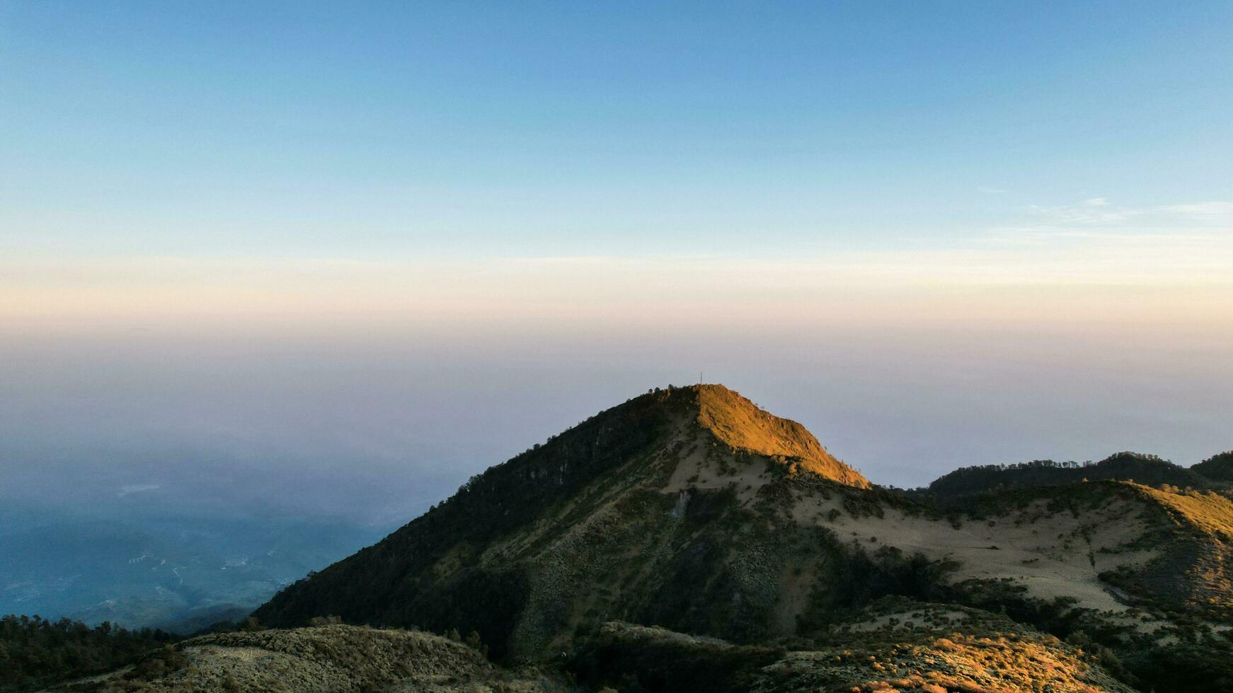 The beautiful Landscape view from Lawu Mountain at sunrise located in Magetan. One of the most beautiful mountains in Java with an altitude of 3265m above sea level. Magetan, Indonesia August 1, 2023 photo