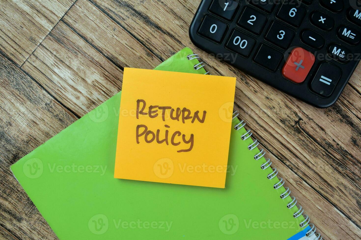 Concept of Return Policy write on sticky notes isolated on Wooden Table. photo