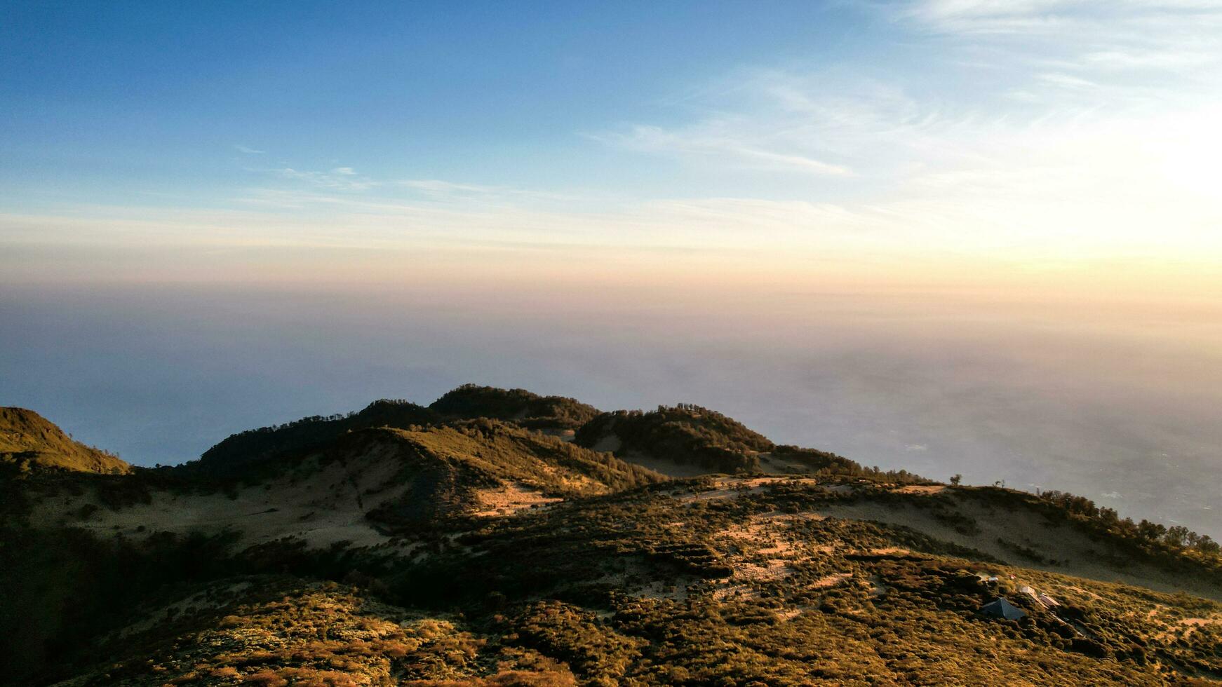 The beautiful Landscape view from Lawu Mountain at sunrise located in Magetan. One of the most beautiful mountains in Java with an altitude of 3265m above sea level. Magetan, Indonesia August 1, 2023 photo