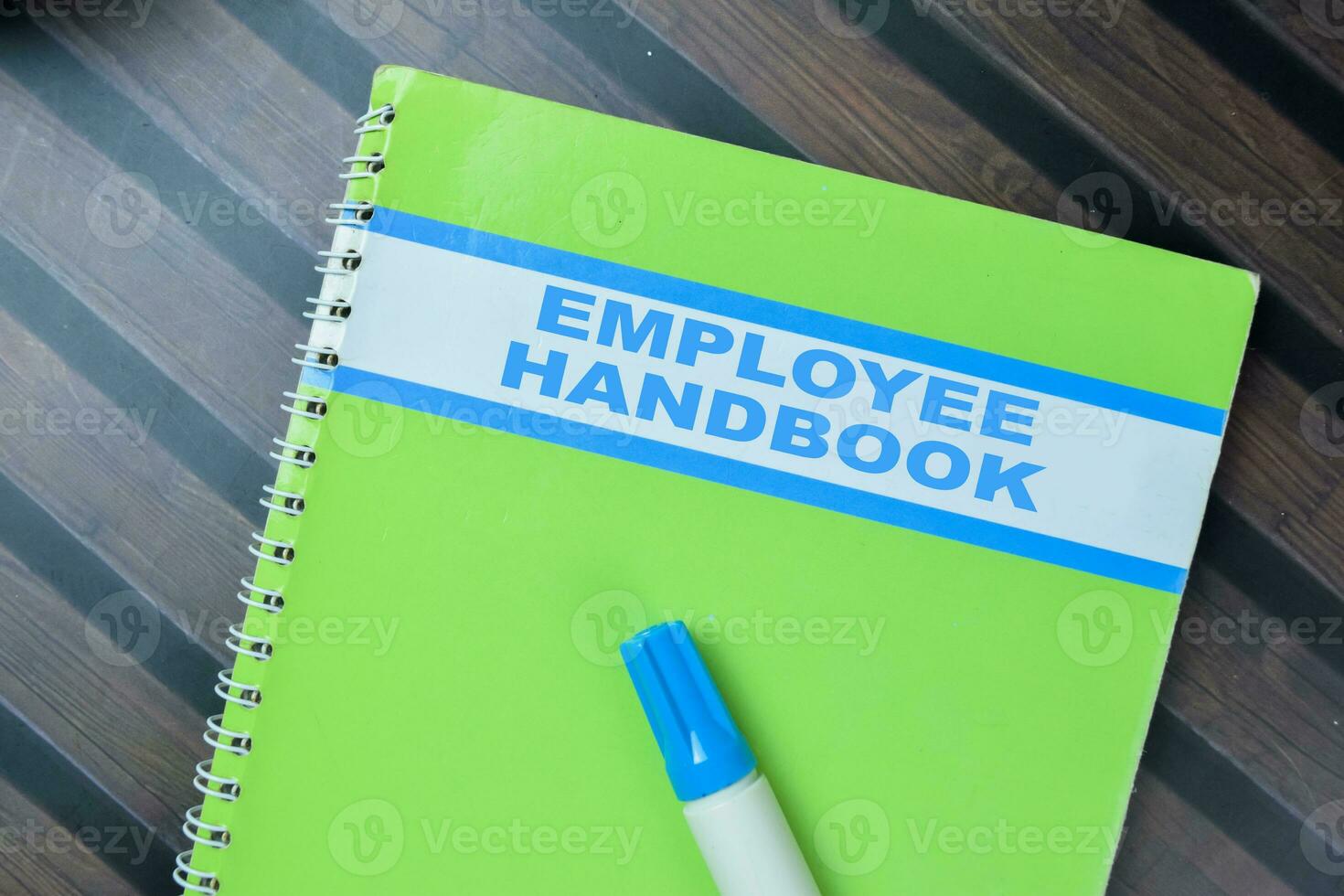 Concept of Employee Handbook write on book isolated on Wooden Table. photo