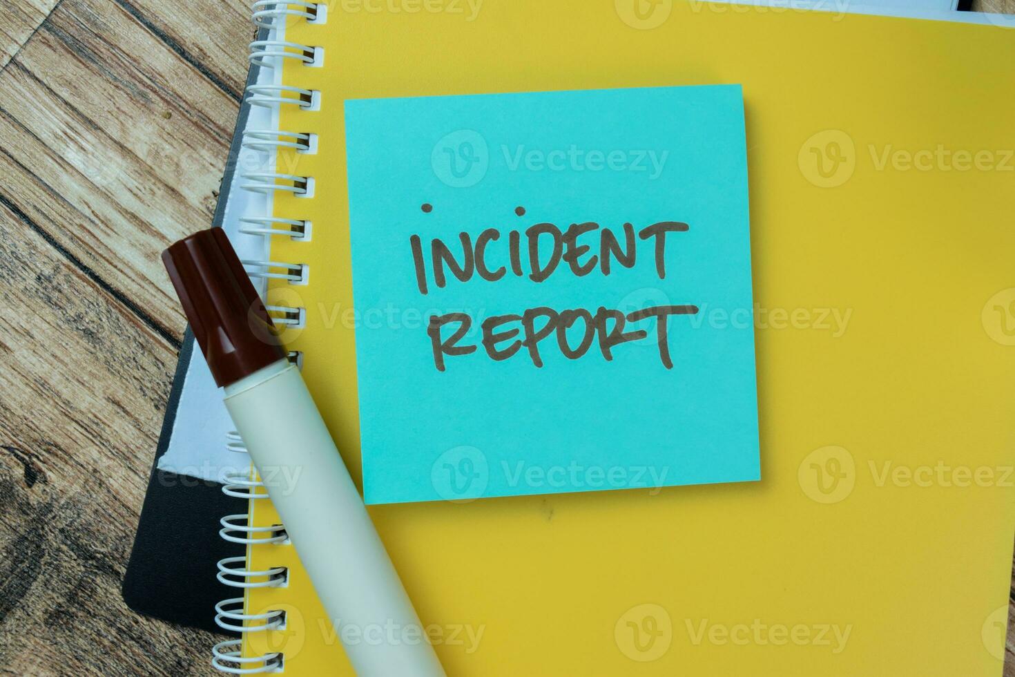 Concept of Incident Report write on sticky notes isolated on Wooden Table. photo