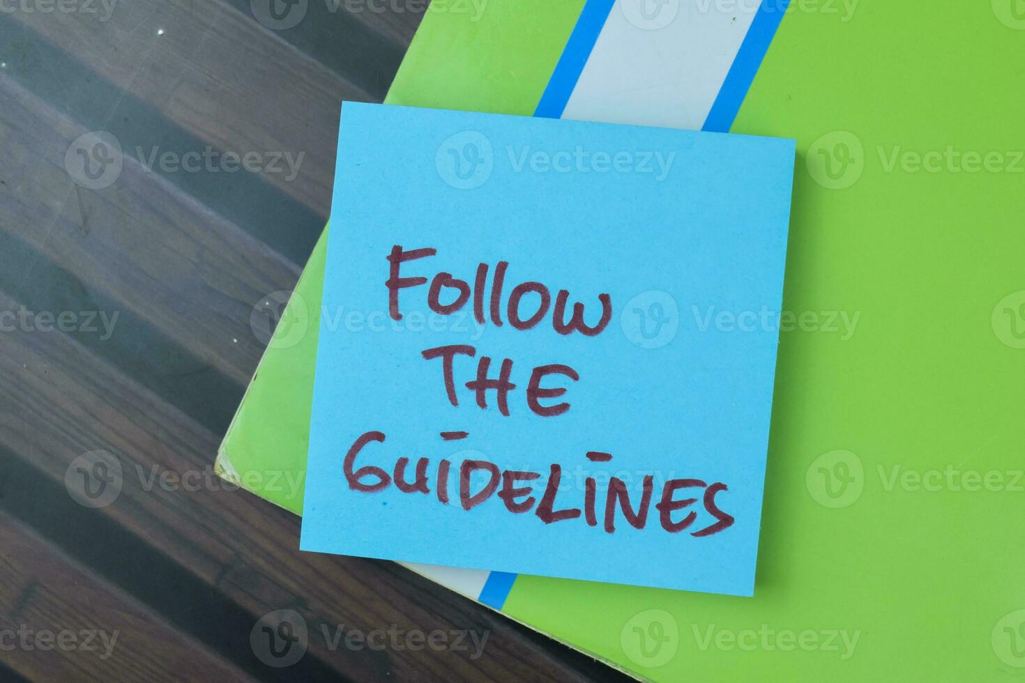 Concept of Follow The Guidelines write on sticky notes isolated on Wooden Table. photo