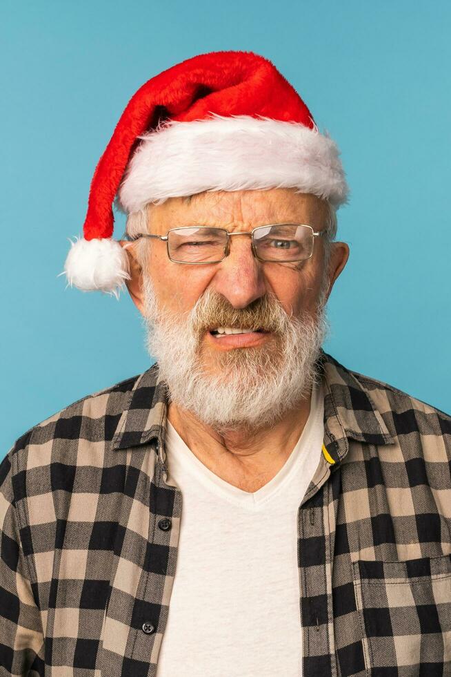 Gloomy angry Santa Claus portrait against blue background. Economy crisis and troubles end of year concept photo
