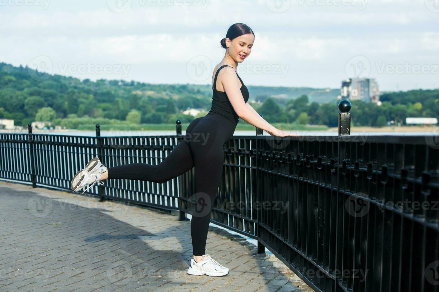 joven mujer en negro ropa de deporte hacer ejercicio al aire libre