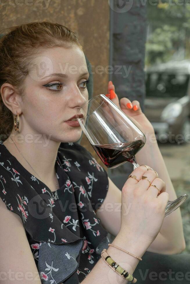 hermosa joven mujer Bebiendo rojo vino en restaurante foto
