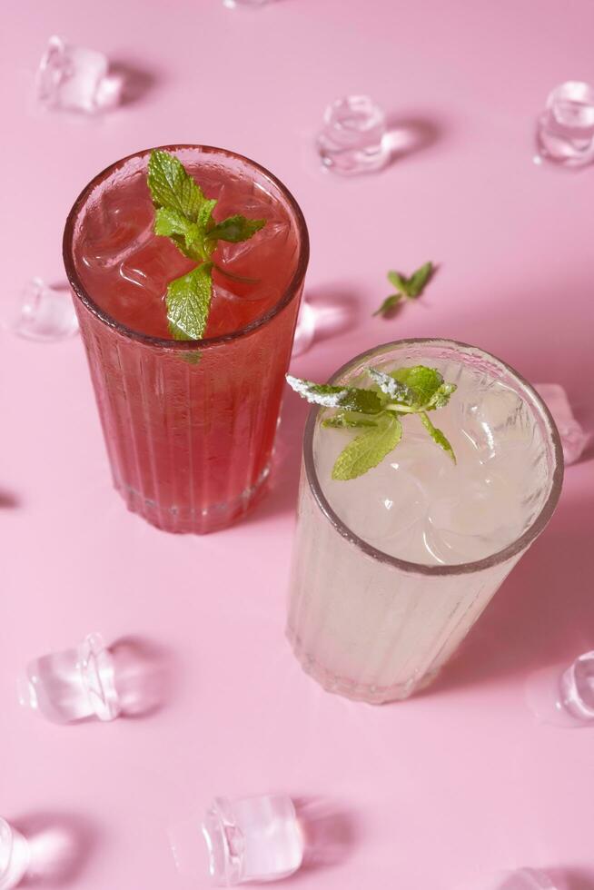 verano limonadas con hielo y menta en vaso lentes parte superior ver en rosado antecedentes. foto