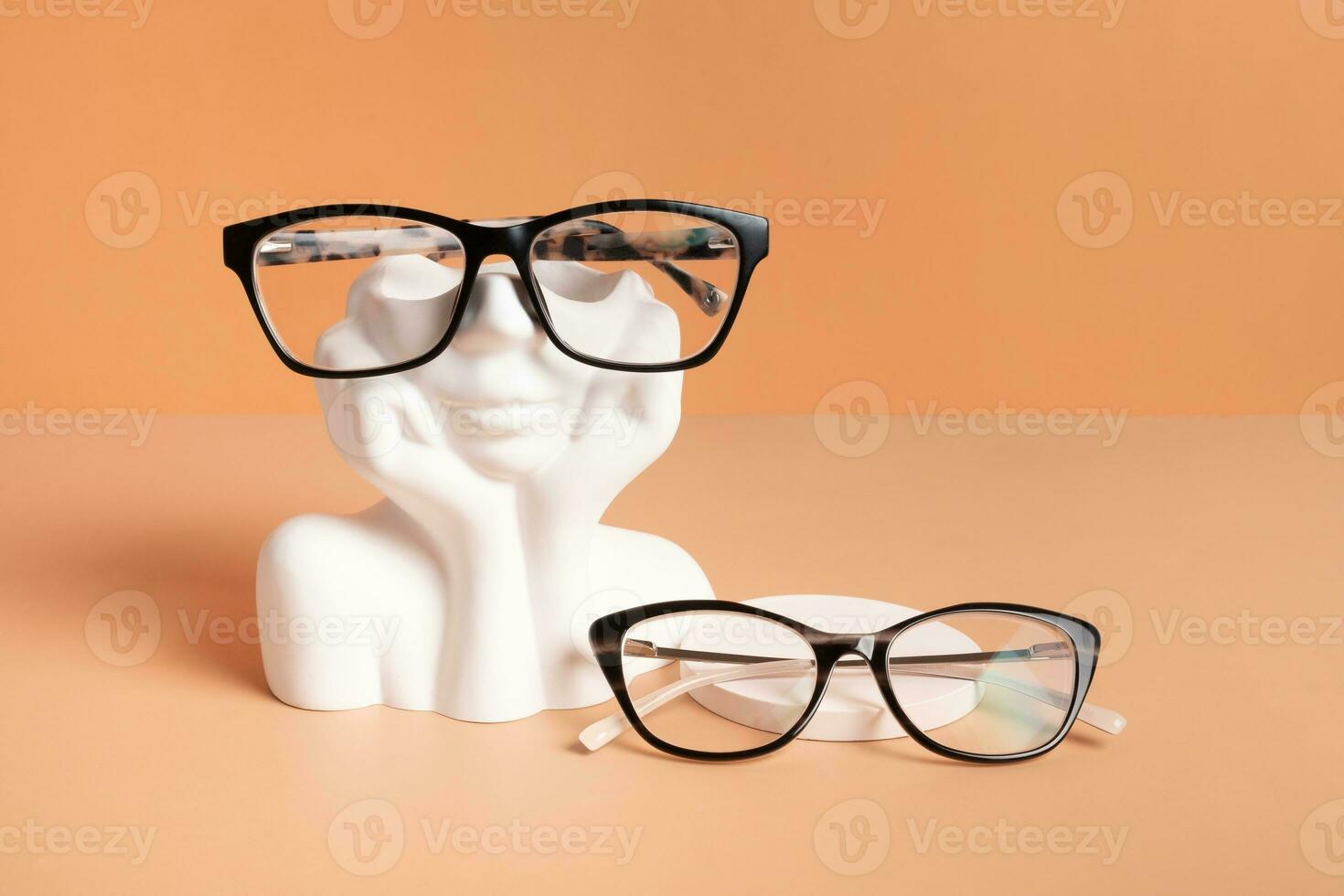 Gypsum head with eyeglasses on colored background. Optical store, vision test, stylish glasses concept photo