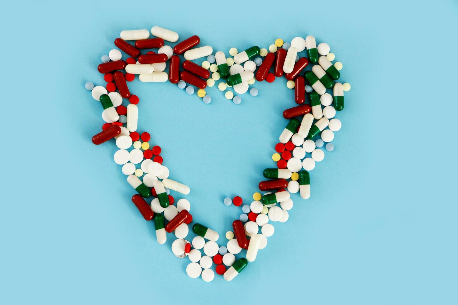 heart made of pills on a blue background photo