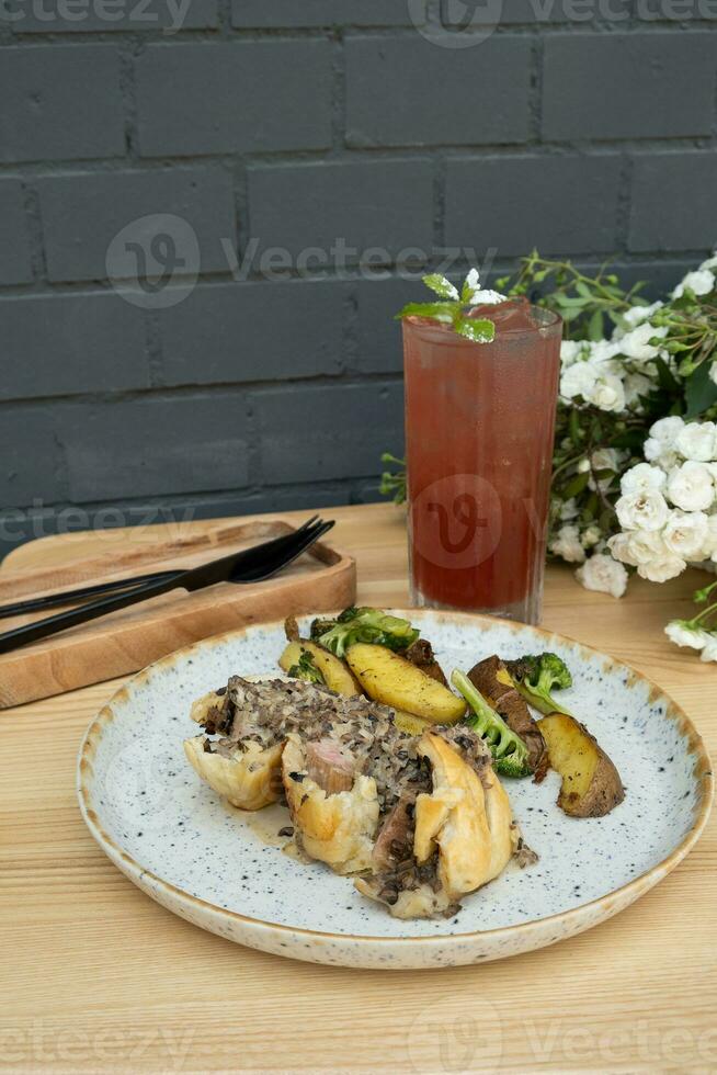 Main course with meat and potatoes and lemonade on a wooden table photo