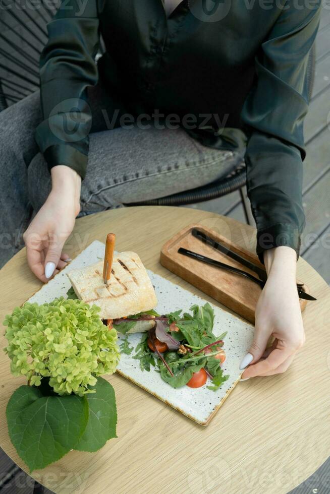 hamburguesa con carne en un de madera mesa en hembra manos foto