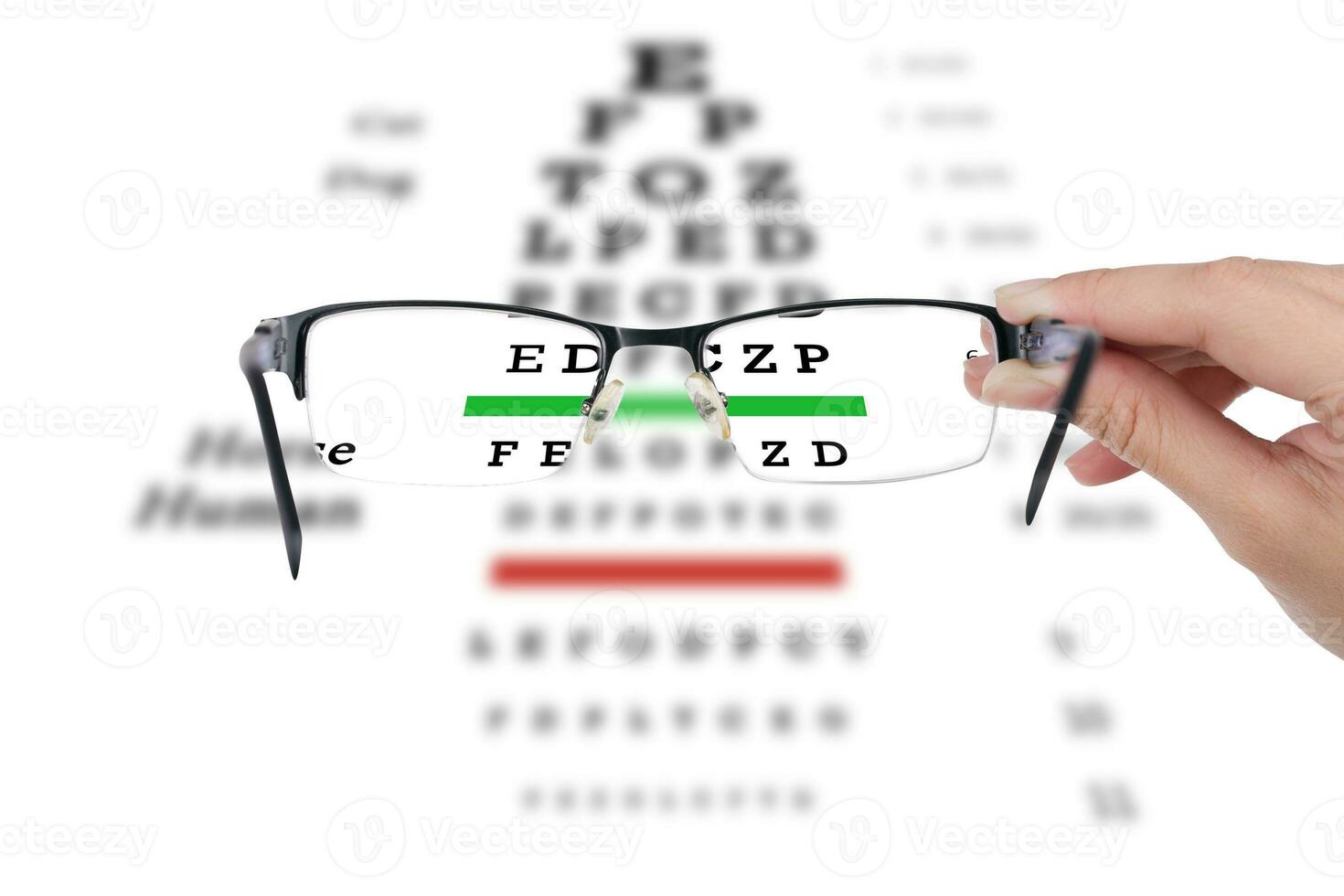 Female hand holding glasses with eyesight test on chart board. photo