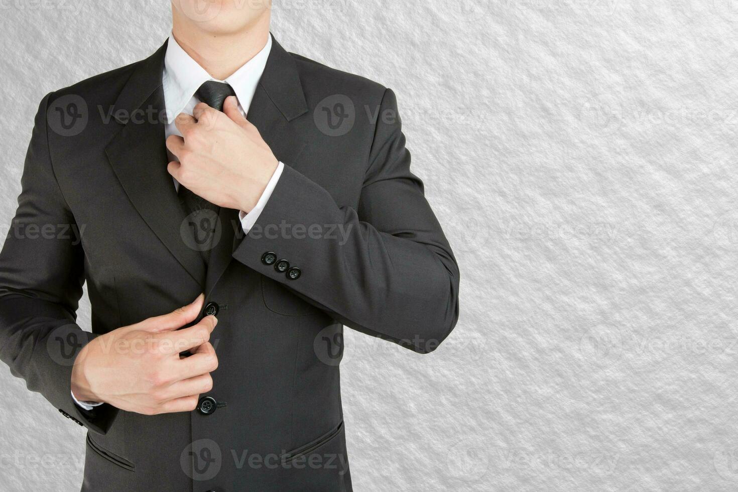 Well dressed businessman looklike smart adjusting  his neck tie on color background photo