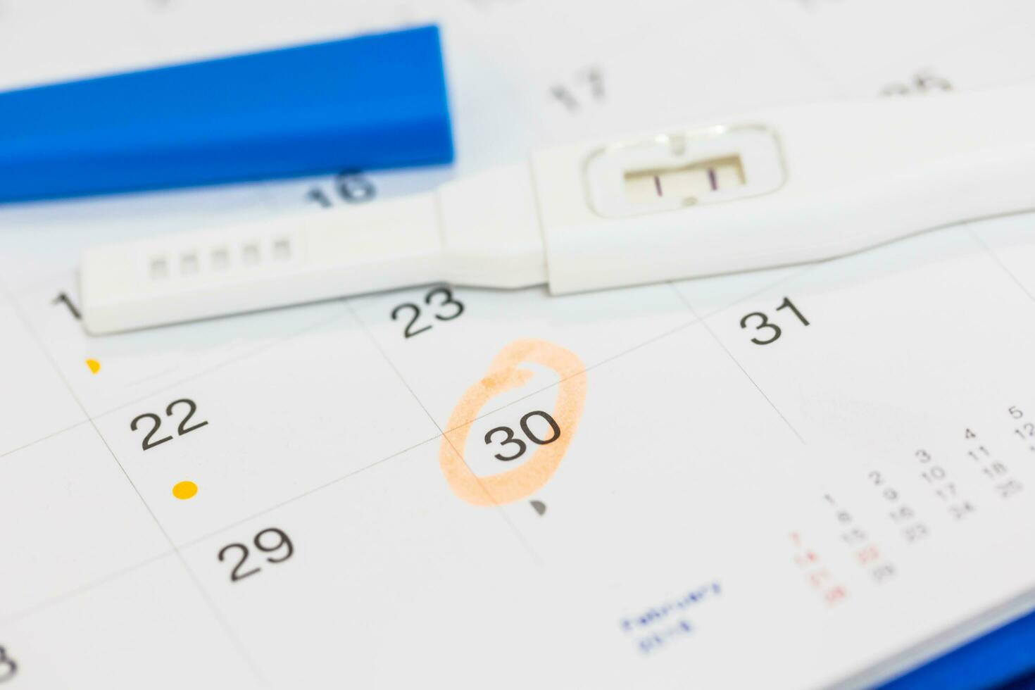 Positive pregnancy test with calendar. photo