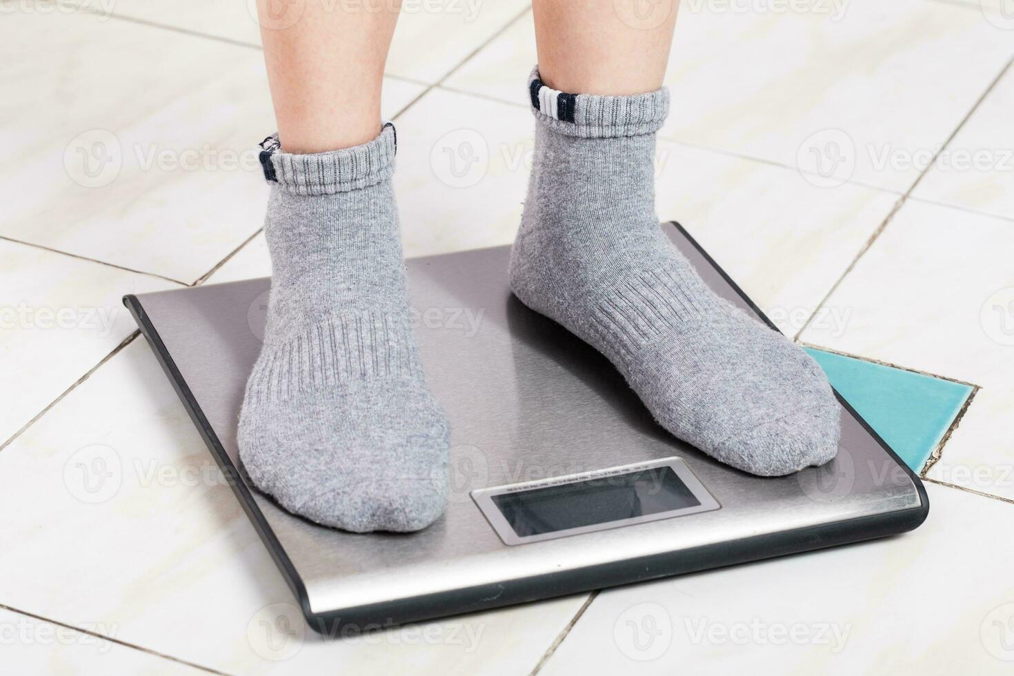 Close up female feet on digital weighting scale. photo