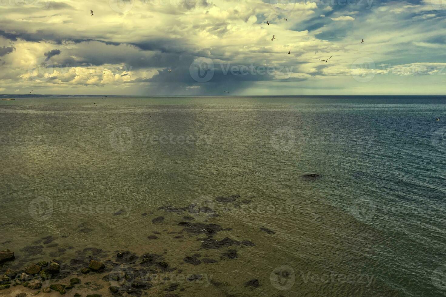 Aerial drone seascape of crystal clear lagoon sea water surface with rocks and cloudy sky photo