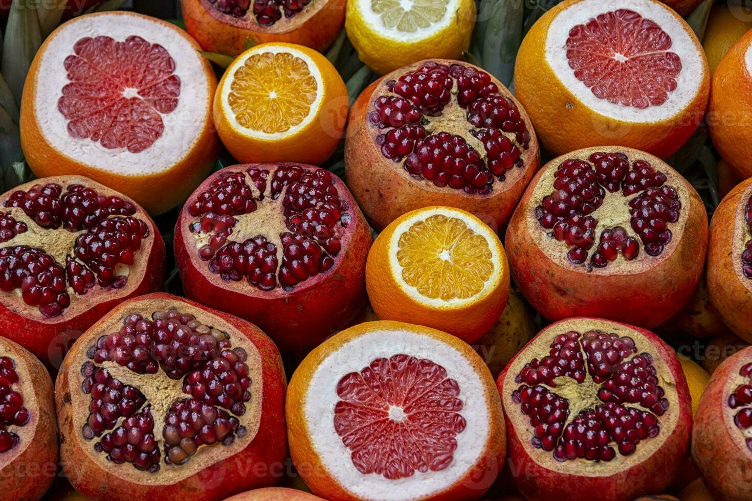 Many opened fruits at a market in Istanbul, Turkey during sunny day. Nice natural background with pomegranates, oranges and grape-fruits. photo