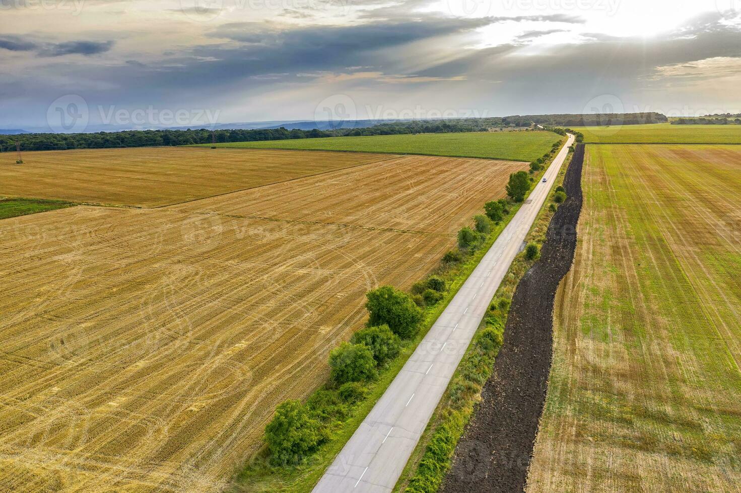 aéreo ver de un rural paisaje con un granja camino, trigo campos después cosecha. foto