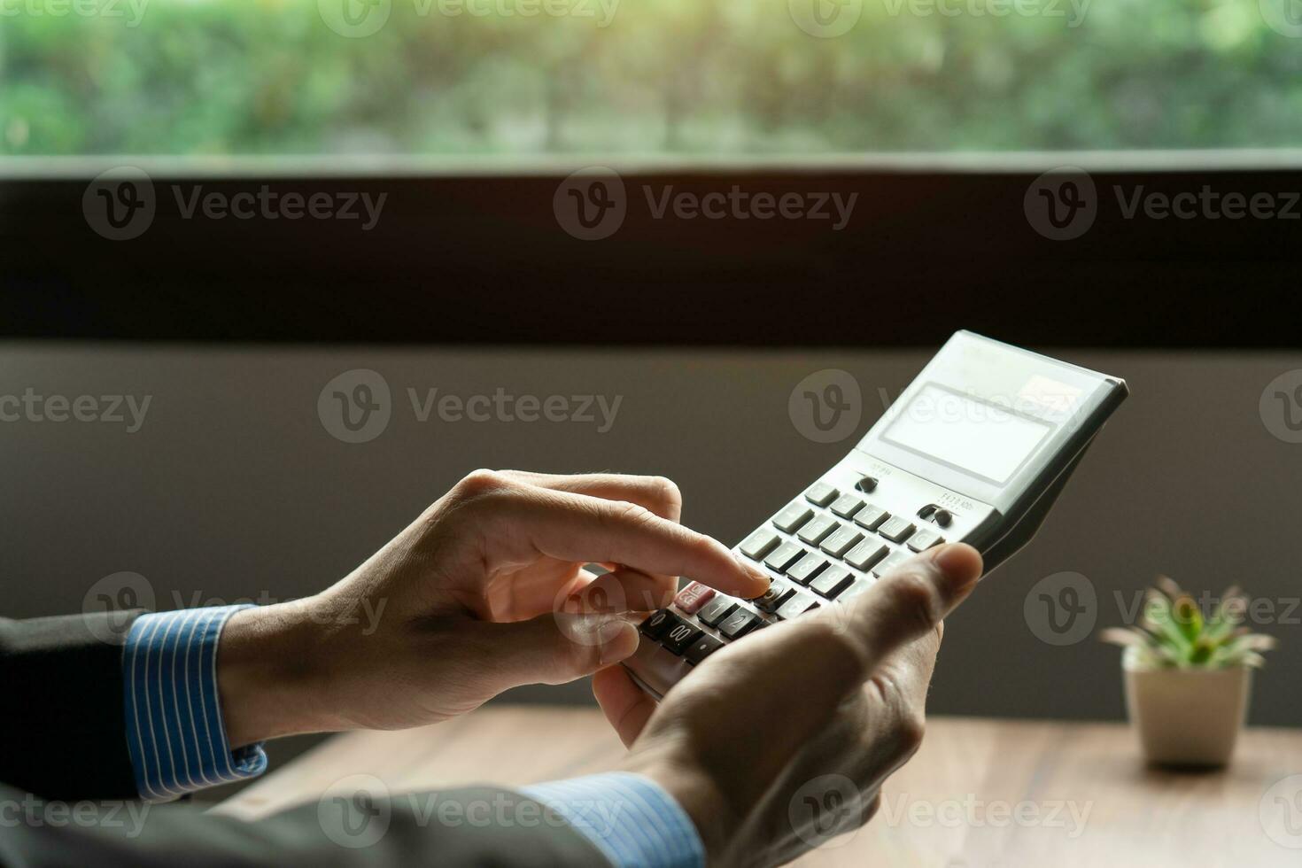businessman or accountant hand using calculator, calculate finance report in office, It aids financial planning and saving to build wealth for the future, long term return on investment photo