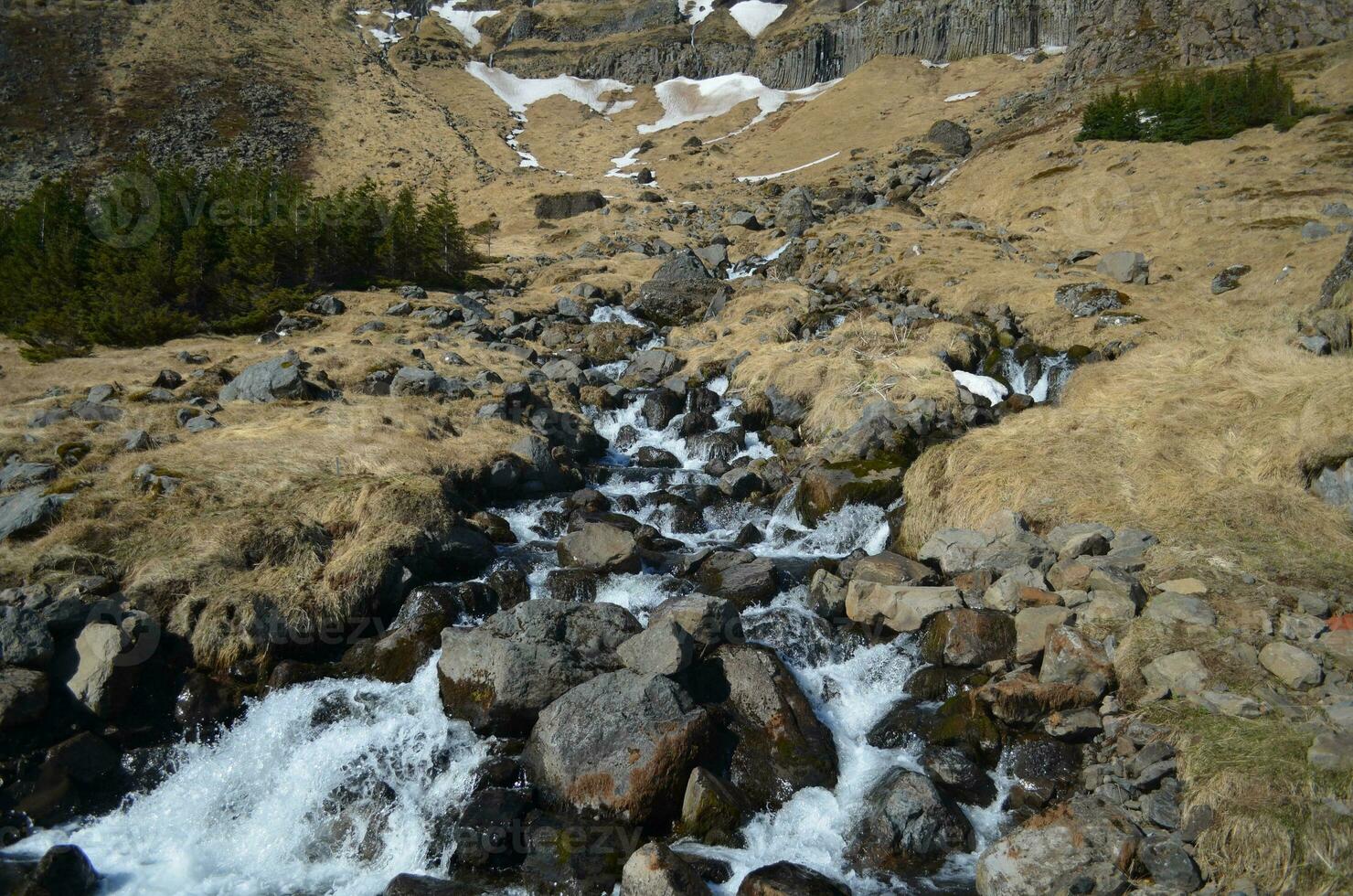 Snow Melt Waterfall Down the Mountain in Iceland photo