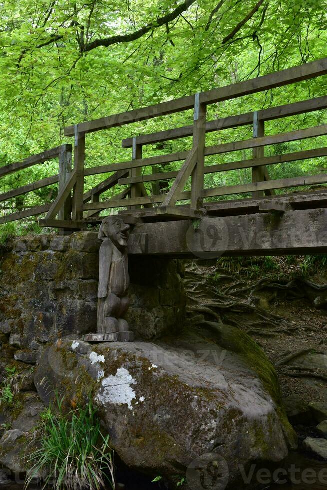 Large Wooden Troll Under a Bridge in the Woods photo